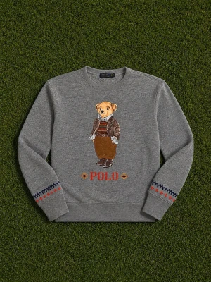 Grå sweatshirt Polo Bear Ralph Lauren - Grå sweatshirt från Ralph Lauren med ikoniska Polo Bear-trycket framtill. Tröjan har rund hals, ribbade muddar och broderade detaljer i rött och blått på ärmarna. Materialet är mjuk bomullsblandning och designen är avslappnad och trendig. Perfekt för dig som gillar streetstyle.