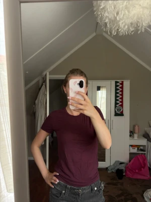 Vin röd basic t-shirt - En enkel och stilren vin röd t-shirt med rund hals och korta ärmar. T-shirten har en normal passform och är tillverkad i mjuk bomull, perfekt för en avslappnad look. Inga synliga tryck eller loggor.