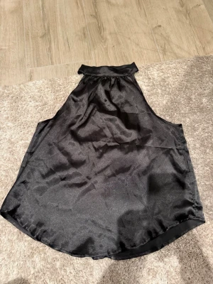 Svart satin halterneck topp SHEIN - Snygg svart halterneck topp från SHEIN i glansigt satinmaterial. Aldrig använt, perfekt till lite festligare kläder eller finare kläder