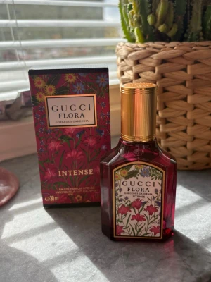 Gucci Flora Gorgeous Gardenia Intense - Gucci Flora Gorgeous Gardenia Intense är en parfym med blommig doft i en elegant, mörkrosa glasflaska med guldfärgat lock. Flaskan har ett färgstarkt blommönster och matchande förpackning. Volymen är 30 ml och designen känns lyxig och ungdomlig. Ny 