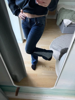 Mörkblå bootcut jeans - Säljer ett par mörkblå bootcut jeans med klassisk femficksmodell och låg midja. Jeansen har en snygg tvätt och lätt utsvängda ben. Perfekta till sneakers eller boots för en avslappnad look. Kan sänka pris vid snabb affär.