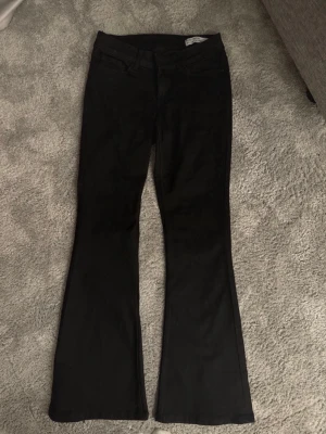 Svarta bootcut jeans Vero Moda - Säljer ett par svarta bootcut jeans från Vero Moda. Jeansen har klassisk femficksmodell, normal midja och utsvängda ben. Perfekta till sneakers eller boots och tillverkade i mjukt denimtyg för skön passform.