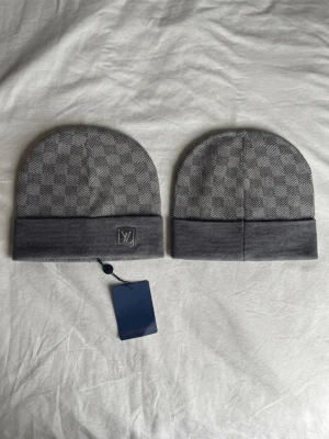 Grå LV Mössa - • Skick: Helt ny (10/10). • Färg: Grå (se bilder för detaljer på både fram- och baksida). • Material: Mjukt och bekvämt material med bra stretch.