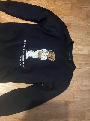 Polo Bear Ralph Lauren - Cool svart sweatshirt från Polo bear Ralph Lauren. SKIT BRA PASSFORM på denna. Ungefär 60 cm lång och 38 cm bredd. Bra skick använt runt 2 veckor 2 gånger