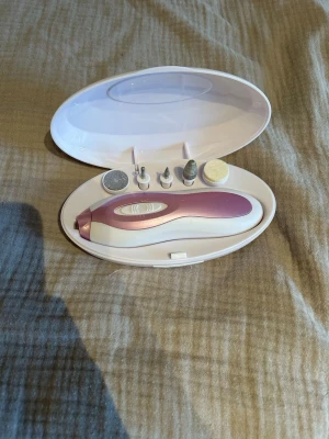 Elektrisk nagelfil med tillbehör - Praktisk elektrisk nagelfil i vit och rosa plast med fem olika sliphuvuden för manikyr och pedikyr. Kommer i ett smidigt vitt etui som håller allt organiserat. Perfekt för att fixa naglarna hemma med olika funktioner för slipning, polering och formning.