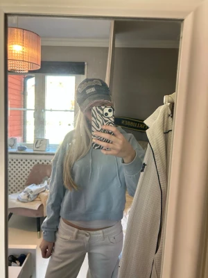 Ljusblå cropped hoodie - Snygg ljusblå cropped hoodie med huva och dragsko. Hoodien har en avslappnad passform och är tillverkad i mjukt bomullsmaterial. Perfekt för en chill och trendig look.