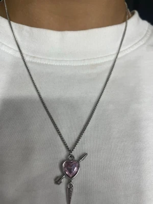  Silvrigt halsband med hjärta och pil - Snyggt halsband i silverfärgad hjärthalsband med en pil har använt de i typ 3veckor. 