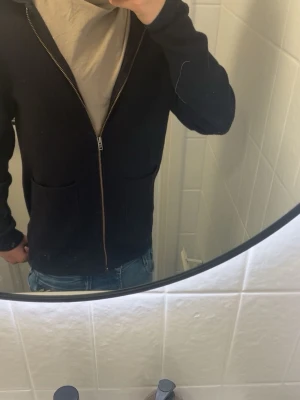 Mörkblå ziptröja - Snygg mörkblå zip hoodie ifrån casual friday. Tröjan är i ett bra skick men det är nobbar på tröjan men tas bort innan tröjan skickas. Jag är 177cm och den är för liten för mig. Den passar dig runt 170. Vid frågor och annat kontakta mig!😊