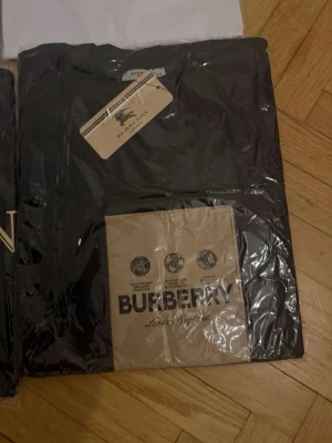 Svart Burberry t-shirt i bomull - Snygg svart t-shirt från Burberry med klassisk logga framtill. De är väldigt bra kvalité finns i storlek m och l också