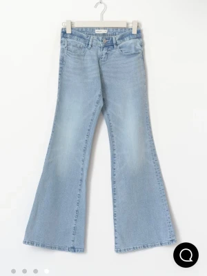 Gina Tricot Jeans - Säljer ett par ljusblå jeans med utsvängda ben och klassisk femficksdesign. Jeansen har hög midja och är perfekta för dig som gillar retrostil. Tillverkade i bomull för en skön känsla och snygg passform.