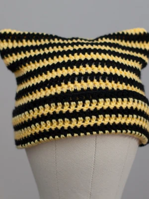 Crochet cat beanie virkad kattmössa gul svart randig  - Helt ny virkad mössa med kattöron. Onesize, passar upp till ca 59cm. Virkad i mjukt akrylgarn. Färger kan variera beroende på skärminställningar.