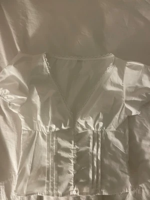 Vit topp - Söt vit topp med korta puffärmar, v- ringning med fina spetsdetaljer. (Lånad andra bild då toppen inte passade mig💞)