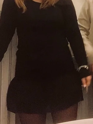 Svart volangkjol med smock - Supersnygg svart kortkjol med smock i midjan och dubbla volanger nedtill. Kjolen har en tight passform upptill och faller snyggt med volanger. Perfekt att styla med en enkel topp eller stickad tröja. Storlek 42 men skulle säga att den passar både mindre och större med tanken på stretchen 