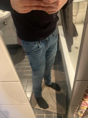 Blå slim fit jeans herr - Säljer ett par blå slim fit jeans med klassisk femficksdesign och normal midja. Jeansen har en snygg tvättad look och smal passform som sitter tajt längs benen. Perfekta för en avslappnad och trendig stil. Materialet är troligtvis bomull med stretch. Skriv för mått. Priset går att diskutera. 