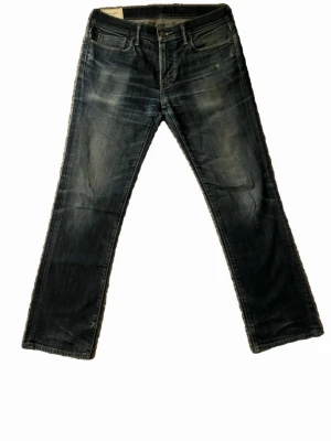 Mörkblå raka jeans med slitningar - Säljer ett par mörkblå jeans med raka ben och snygga slitningar framtill. Klassisk femficksmodell och normal passform. Perfekt passform och riktigt bra skick! 