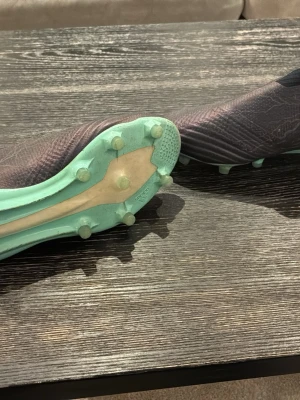 Adidas Ace 17+ - Säljer ett par Adidas Ace  fotbollsskor i svart med turkosa detaljer och dobbar. Skorna har en strumpliknande passform och är tillverkade i syntetmaterial för bra grepp och kontroll på planen. Snygg design med blixtmönster på sidan och låg vikt för snabbhet. Ganska bra skick på dom. Hittade dom på nätet från allt mellan 2000-5000kr, vet dock ej värde då dom är ganska gamla.