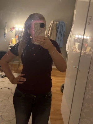 Mörkröd basic t-shirt - En enkel och stilren mörkröd t-shirt med rund halsringning och korta ärmar. Perfekt att matcha med jeans eller kjol för en avslappnad look. T-shirten har en normal passform och är tillverkad i ett mjukt material.