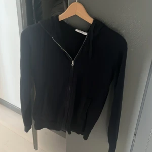 Mörk blå  zip hoodie med huva - Säljer en  mörk blå zip hoodie från märket ryvls med dragkedja framtill och huva,. Tillverkad i mjukt material och har långa ärmar samt ribbade muddar vid ärmslut och nederkant. Perfekt för en avslappnad och stilren look.