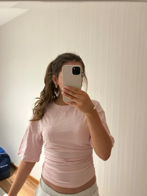 Ljusrosa topp med kort ärm - Säljer en ljusrosa topp med korta ärmar och rund halsringning💕