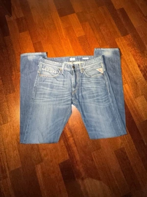 Blå Replay jeans anbass - Säljer ett par klassiska blå jeans från Replay har aldrig andvänt de på grund av storlek. De har raka ben och snygga slitningar. Jeansen har fem fickor, ljus tvätt och Replay-logga på bakfickan samt läderpatch i midjan. Perfekta för en avslappnad och trendig look.