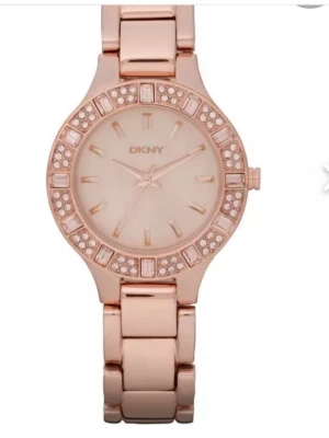 Roséguldklocka från DKNY med stenar - Snygg klocka från DKNY i roséguld med länkarmband och glittrande stenar runt urtavlan. Urtavlan är stilren med minimalistiska markeringar och DKNY-logga. Perfekt accessoar för att lyfta din outfit.