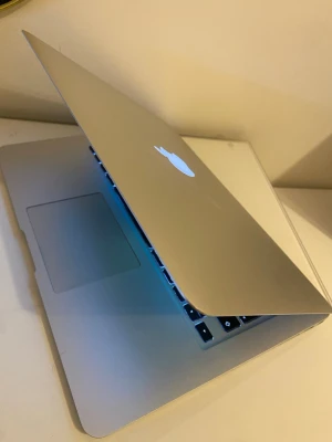 MacBook Air 13 tum (2015) - Säljer en stilren MacBook Air 13 tum i silver med bakgrundsbelyst tangentbord och stor trackpad. Datorn har en tunn och lätt design i aluminium, perfekt för dig som vill ha en smidig laptop att ta med överallt. Klassisk Apple-logga på locket och skarp skärm. Laddare finns med.
