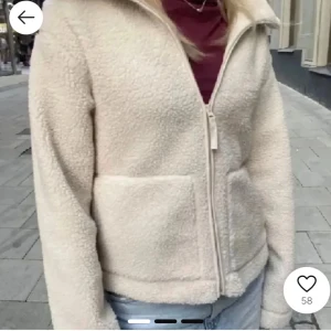 Beige teddyjacka med dragkedja från hm  - Mysig beige teddyjacka med dragkedja framtill. Perfekt för höst dagar med sin fluffiga design. Jackan har långa ärmar och två praktiska fickor.