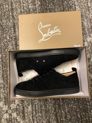 Svarta Christian Louboutin skor  - Stilrena svarta sneakers i mocka från Christian Louboutin med klassisk röd sula och diskreta svarta snören. Storlek är 44 och dem är i helt nytt skick med inga hål eller skavanker. Priset kan diskuteras och skickar inom 24tim😊💨