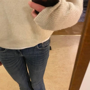 Blå bootcut jeans med låg midja - Säljer ett par klassiska blå bootcut jeans med låg midja och fina detaljerade fickor. Jeansen har en snygg tvättad look. Säljer för dom är för korta för mig i benen.