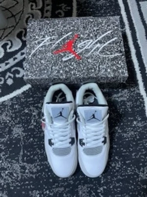 Air Jordan 4 Military Black - Snygga Air Jordan 4 Military black sneakers i vitt läder med vit och svarta detaljer. Klassisk siluett med meshpaneler och Jumpman-logga på plösen. Kommer med originalkartong med Flight-tryck. Perfekta för dig som gillar streetwear och ikoniska sneakers.