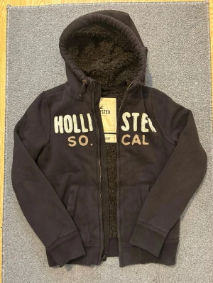 Pälsfodrad Vintage Hollister Kofta - Säljer denna snygga Hollister koftan som även är pälsfodrad, varm & skön till kalla dagar | Mycket bra skick | Storlek S | Längd ≈ 68cm, Bredd armhåla-armhåla ≈ 57cm | Modell 175, 68kg