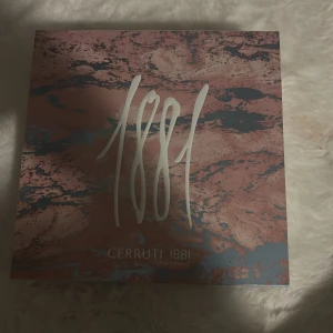 Cerruti 1881 Pour Femme parfym - Cerruti 1881 Pour Femme parfym i en elegant förpackning med marmorerat rosa och grått mönster. Stora siffror '1881' pryder framsidan och märket Cerruti syns tydligt. En klassisk och stilren doft för kvinnor.