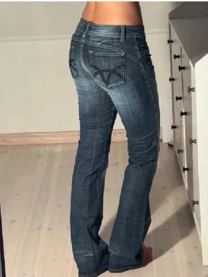 Blå bootcut jeans  - Säljer ett par blå bootcut jeans med snygga broderade detaljer på bakfickorna💕