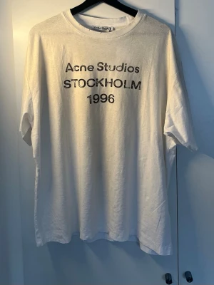 Vit Acne Studios t-shirt Stockholm - Vit t-shirt från Acne Studios             STOCKHOLM 1996' på bröstet.                 Oversized passform och klassisk runt halsen.                                Fick den i present men var lite för stor så har aldrig riktigt använt den.                                               Skriv om du har funderingar, pris kan diskuteras.