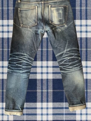 Raw japanese selvedge denim - Säljer eller byter dessa Tvärfeta 21 Oz selvedge jeans med asfeta honeycombs och fades. De är slimfit men sitter lite mer relaxed. Storlek 31 i midjan och längden passa mig perfekt som är runt 176-180. Märket heter ”The undbranded brand” och är brodermärket till ”naked & famous”. Vid byte så är andra selvedge intressant. Helst nudie och straight\loose fit. Skickar snabbt. MÅTT: innerbenslängd: 70cm, benöppning: 15cm, midja: 41cm, ytterbenslängd: 100cm