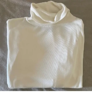 Ralph Lauren tröja - Säljer en oanvänd äkta Ralph Lauren polotröja. Har Ralph lauren märket vid ena bröstet (se bild 3). Helt ny, oanvänd men har inte lappen kvar. Färgen är ungefär offwhite. Storlek syns detaljerat på bild 4 (sitter som ett märke upptill bak under) men skulle säga att den är ungefär xs. Köparen betalar frakten!