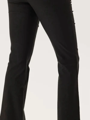 Svarta utsvängda kostymbyxor  - Snygga svarta kostymbyxor med utsvängda ben och klassisk passform. Byxorna har normal midja och är tillverkade i mjuk manchester som ger en trendig retrovibe. Perfekta för dig som vill ha en cool och tidlös look.