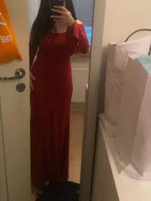 röd klänning / röd fest klänning - Elegant vinröd långklänning med offshoulder-design och långa ärmar. Klänningen har en smickrande, figurnära passform och är perfekt för speciella tillfällen. Tidlös och stilren look som verkligen sticker ut.