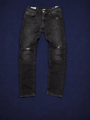 Svarta slitna jeans från Dondup - Snygga svarta jeans från Dondup med slitningar och schysst tvätt. Väl använda så inte helt perfekta. Vid minsta fråga hör av er!