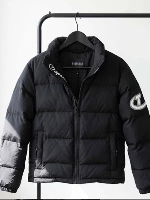 Svart pufferjacka från Trapstar - Säljer en svart pufferjacka från Trapstar perfekt till vinter eller kalla vår kvällar och är självklart äkta! Priset är ej hugget i sten och vid frågor och funderingar så är det bara att höra av sig! Storlek XL men passar även L 