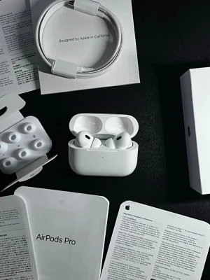 Apple AirPods Pro trådlösa hörlurar - Säljer ett par vita Apple AirPods Pro med laddningsetui, extra silikonpluggar och laddningskabel. Hörlurarna har en stilren och kompakt design i plast och levereras med originalförpackning och manualer. Perfekta för musik, samtal och träning.