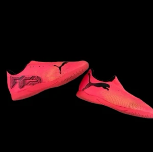 Puma Future 7 inomhusskor neonröda - Säljer ett par neonröda Puma Future 7 fotbollsskor med svart logotyp och detaljer. Skorna har en låg profil och är tillverkade i syntetmaterial med mönstrad sula för bra grepp på planen. Perfekta för dig som vill sticka ut och ha kontroll på bollen.