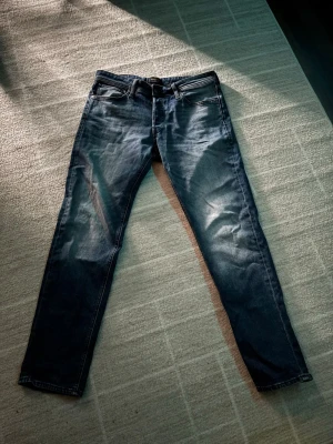 Mörkblå regular fit jeans - Snygga mörkblå regular fit jeans med klassisk femficksdesign och subtila slitningar framt/formade knän. Jeansen har en rak ankel och är tillverkade i gravt tvättad denim som ger en cool, avslappnad look. PRISET KAN DISKUTERAS