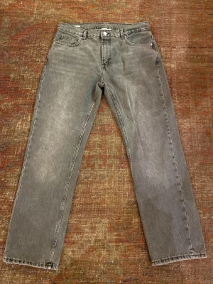 Grå raka jeans från Vailent - Ett par grå jeans med rak passform och klassisk femficksdesign. Jeansen har en tvättad vintage-look och är tillverkade i denim. Perfekta för dig som gillar en avslappnad och tidlös stil. Använda fåtal gånger. Mycket bra skick.