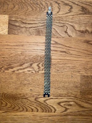 Silvrigt metallarmband i länkdesign - Snyggt armband i rostfritt stål med klassisk länkdesign i silverfärg. Armbandet har en stilren och tidlös look med viklås som gör det enkelt att ta på och av. Perfekt för dig som gillar en clean och modern stil.