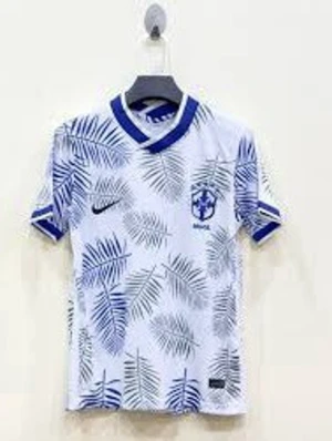 Nike Brasil fotbollströja palmblad - Säljer en snygg Brasilien fotbollströja från Nike med blå palmbladsmönster på vit botten. Tröjan har blå detaljer vid krage och ärmslut samt Brasil-logga och Nike swoosh på bröstet. Perfekt för dig som vill sticka ut på planen eller gatan.