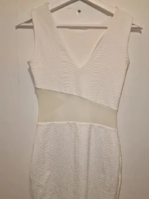 Vit mesh-klänning  - Vit sensuell klänning med ormmönster och meshdetaljer. Den har en modern och fräsch look. Perfekt till studenten 🤍🌺