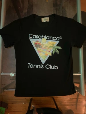 Svart Casablanca Tennis Club t-shirt - Snygg svart t-shirt från Casablanca med stort färgglatt tryck på bröstet och texten 'Casablanca Tennis Club'. Är i storlek M men sitter lite mer som S
