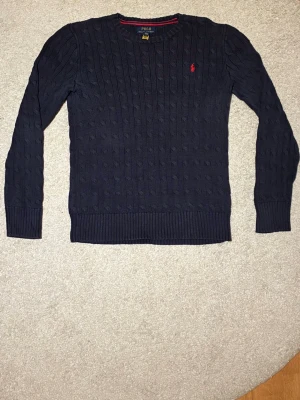 Mörkblå kabelstickad tröja Polo Ralph Lauren - Tjena! Säljer nu en ralph lauren tröja som är stickad. Skulle säga att den passar dig som är 160-170. Skriv vid funderingar!