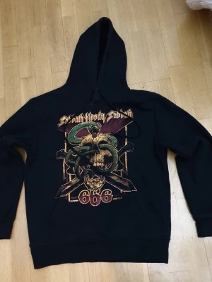 Black Sabbath Huvtröja / Hoodie | M / Medium - Huvtröjja med Black Sabbath tryck på framsidan.  Frazier Ave Medium (Mått finns på bilderna!) 60% bomull. 40% polyester.  Noppor förekommer!  Se bilder.